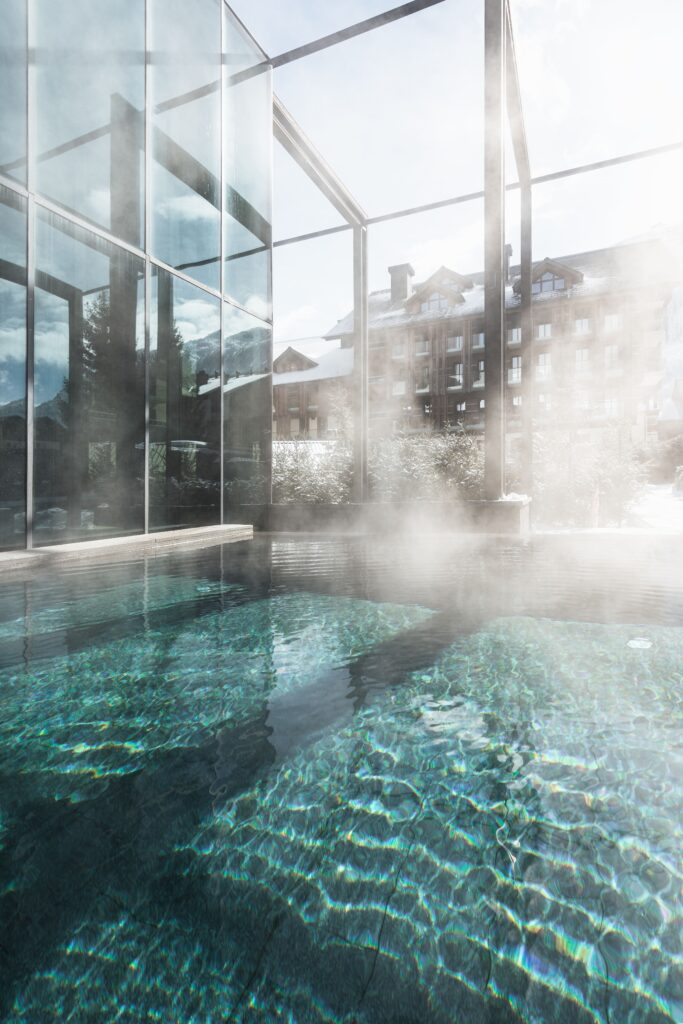 A steaming soaker pool with a mountain view. 