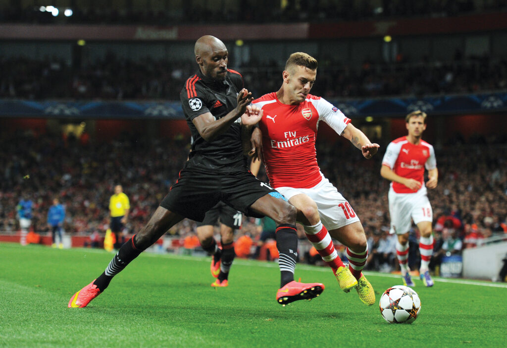 Atiba Hutchinson playing soccer during a match, showcasing his athleticism and competitive spirit on the field, reflecting themes of identity and belonging in his career.