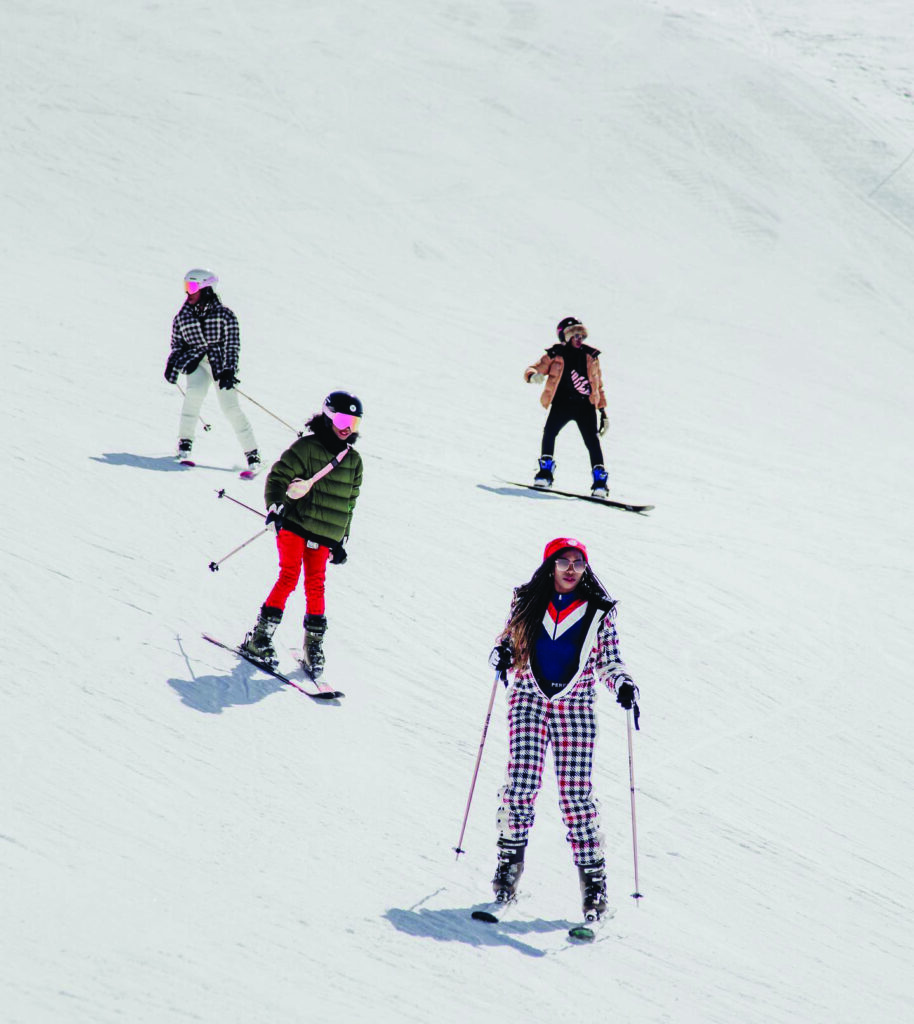 Group of Black skiers on snowy slope, showcasing diversity in winter sports, wearing colorful ski attire and helmets, promoting inclusivity in skiing.