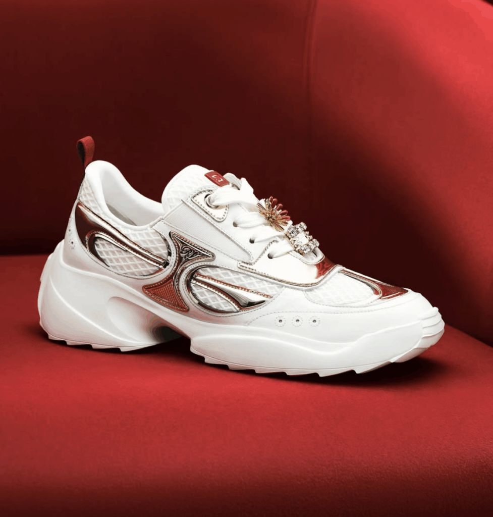 Luxury white sneaker with metallic accents and decorative embellishments, set against a red background, highlighting fashion trends for Lunar New Year celebrations.