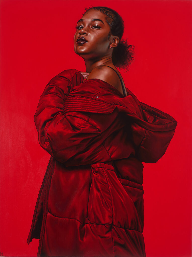 Portrait of a woman in a vibrant red puffer jacket against a matching red background, showcasing contemporary art's connection to hip-hop culture at the Art Gallery of Ontario's exhibit.