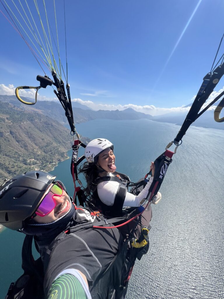 Paragliding duo enjoying an exhilarating experience over a scenic lake, showcasing adventure and empowerment for women travelers.